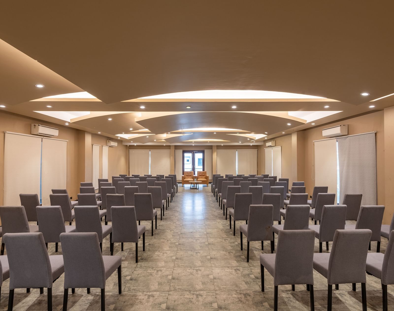 View from the back of the banquet hall at DLS Forest Vines Resort, with chairs neatly arranged on both sides.